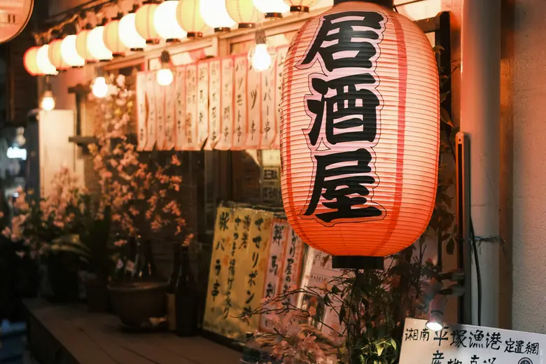 Lantern-lit izakayas on Hoppy Street after dark.