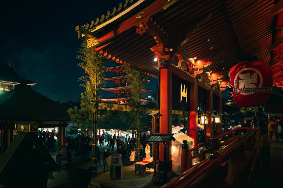Red izakaya lanterns down a narrow street after dark.