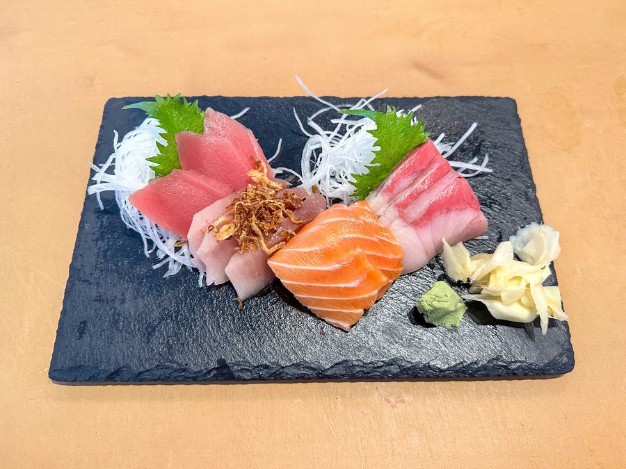 A sashimi platter on a slate board.